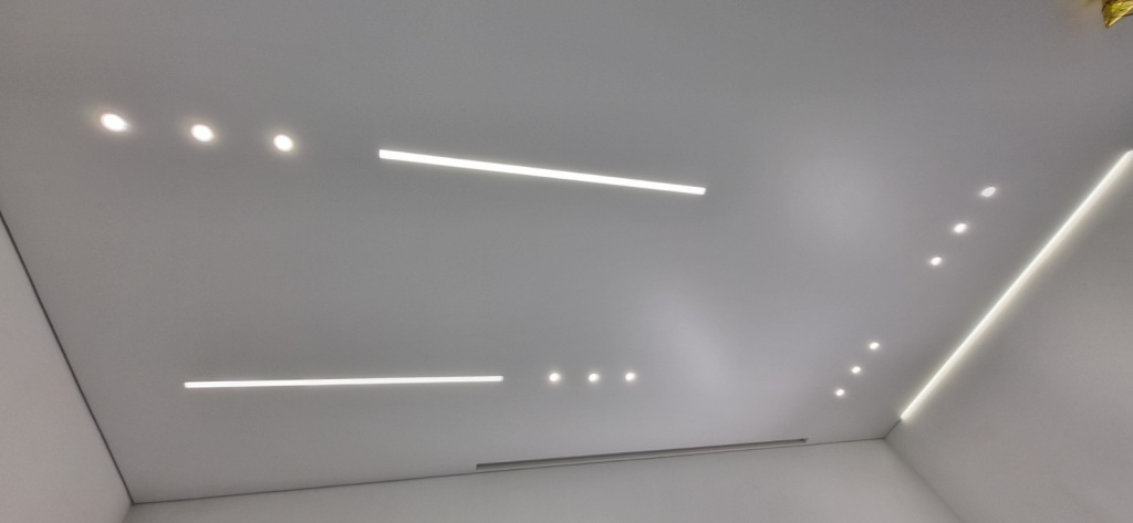 Натяжной потолок со световыми линиями и профилем под карниз